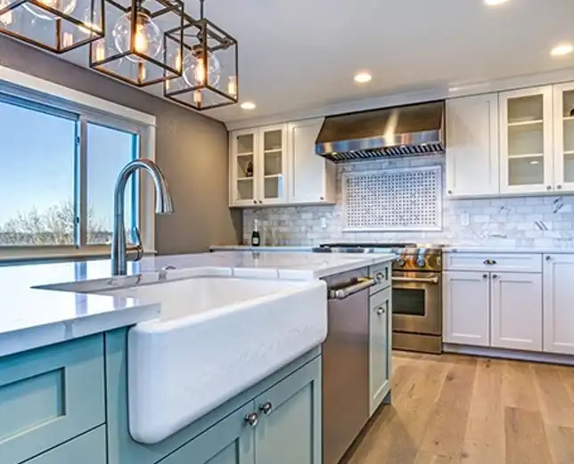 A kitchen with white cabinets and a sink.