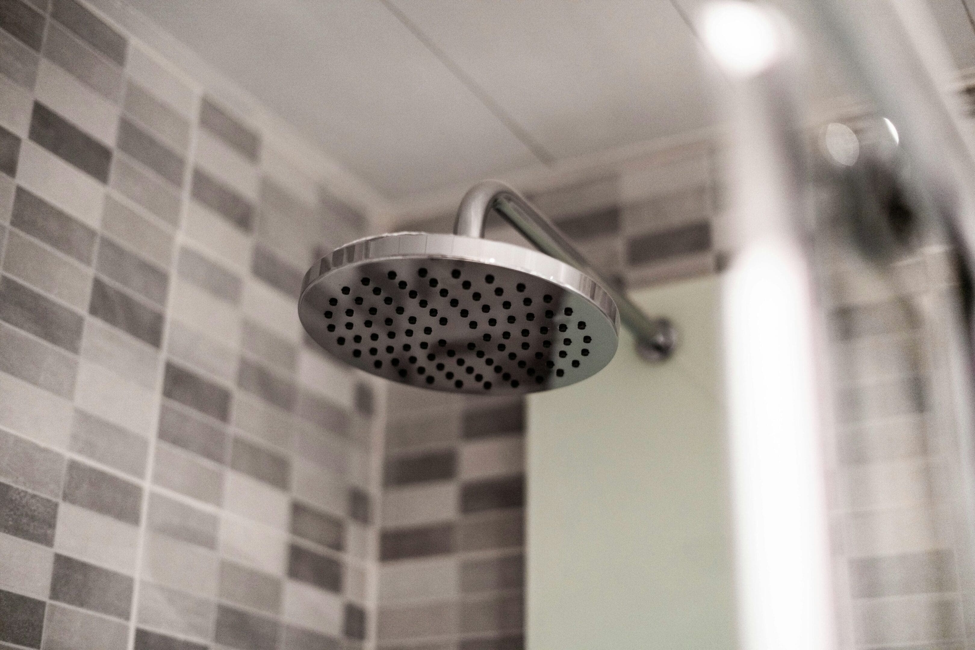 A shower head hanging from the ceiling of a bathroom.